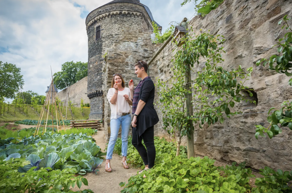 Duas mulheres comendo morangos colhidos dos jardins comestíveis da cidade.